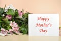 Flowers and greeting card with Happy MotherÃ¢â¬â¢s Day message